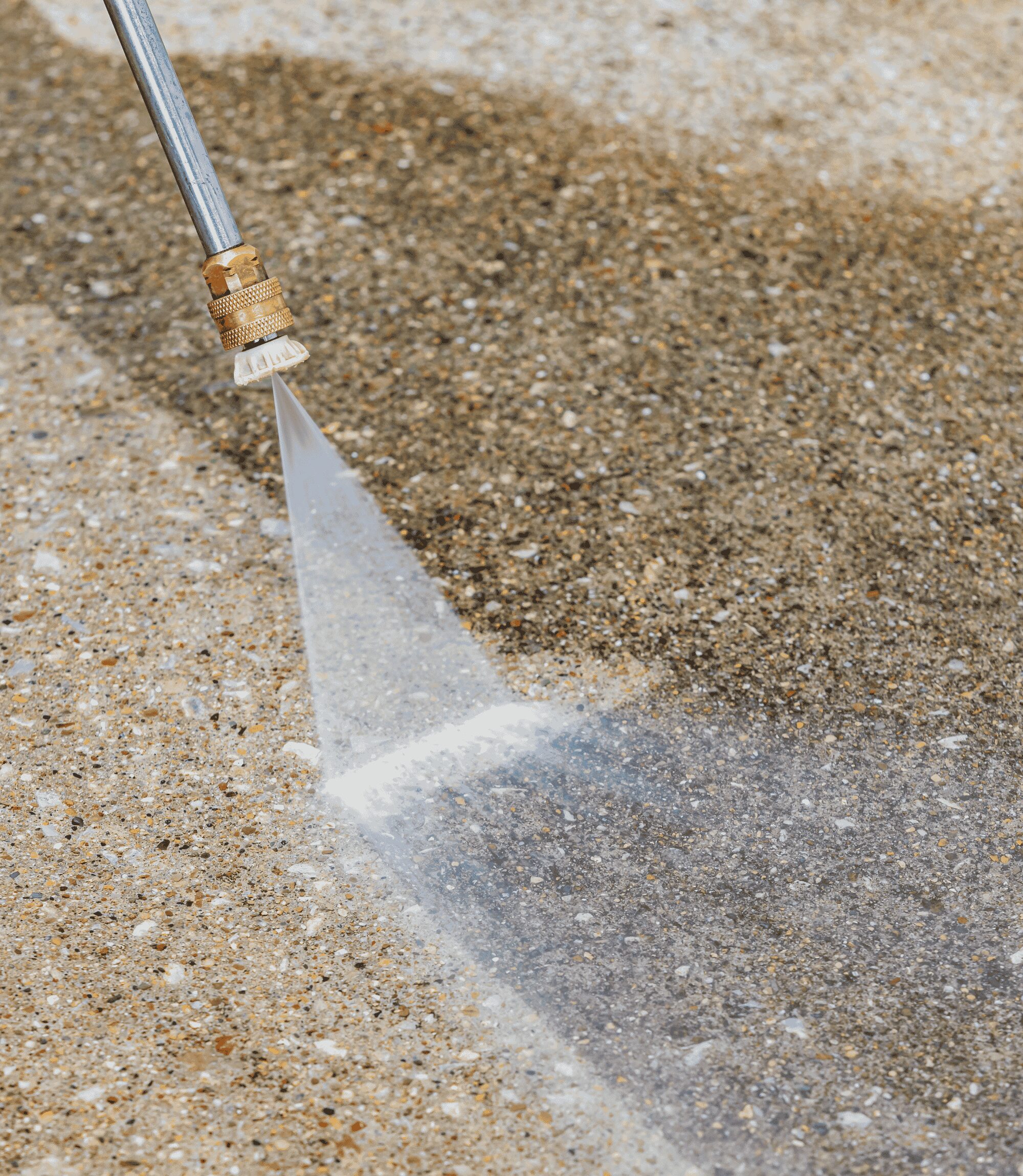 Close-up of pressure washer nozzle spraying water stream on concrete paver surface during cleaning and sealing service