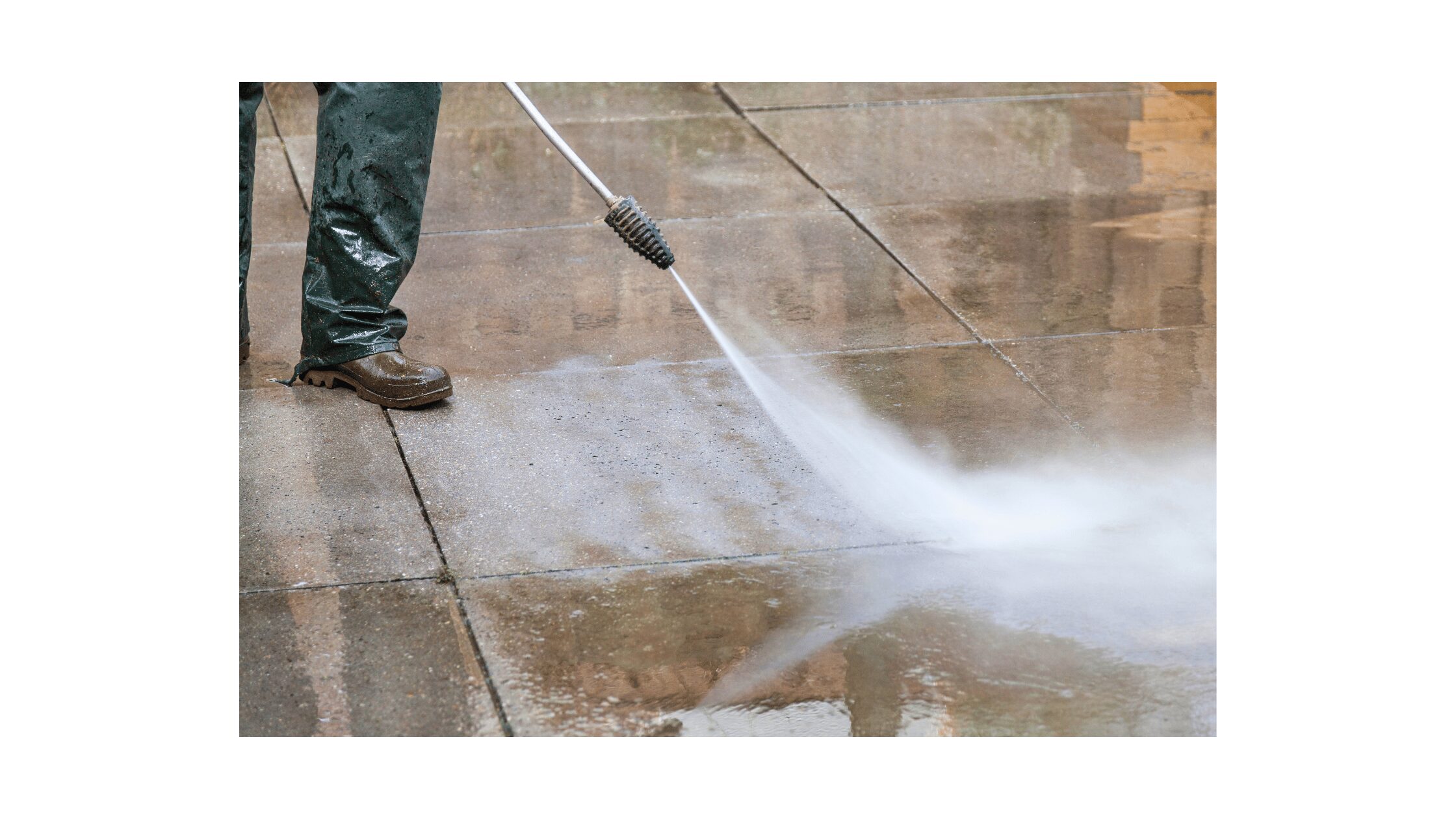 Worker pressure washing concrete pavers with high-pressure spray nozzle, removing dirt and debris from sealed surface