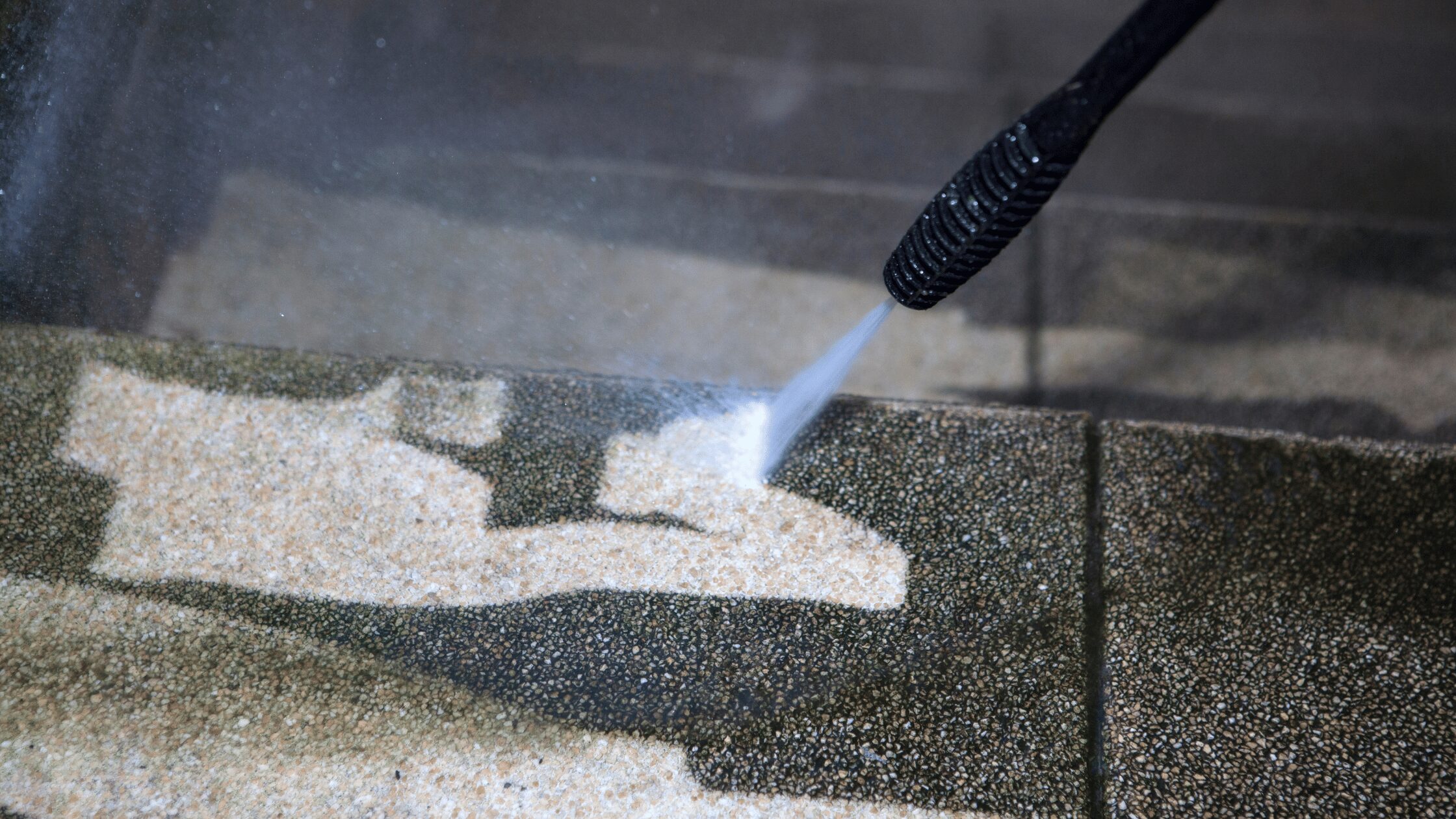Pressure washing stone stairs to remove dirt and debris, revealing clean stamped concrete surface during restoration cleaning process